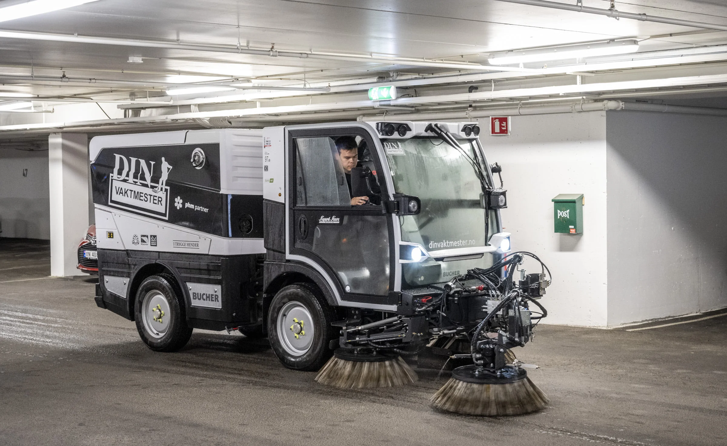 Feiemaskin med roterende børster rengjør gulv i parkeringshus