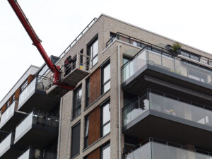 Arbeidsplattform på lift ved moderne leilighetsbygg.